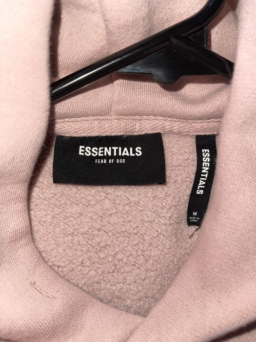 pink women's fear of god essentials hoodie