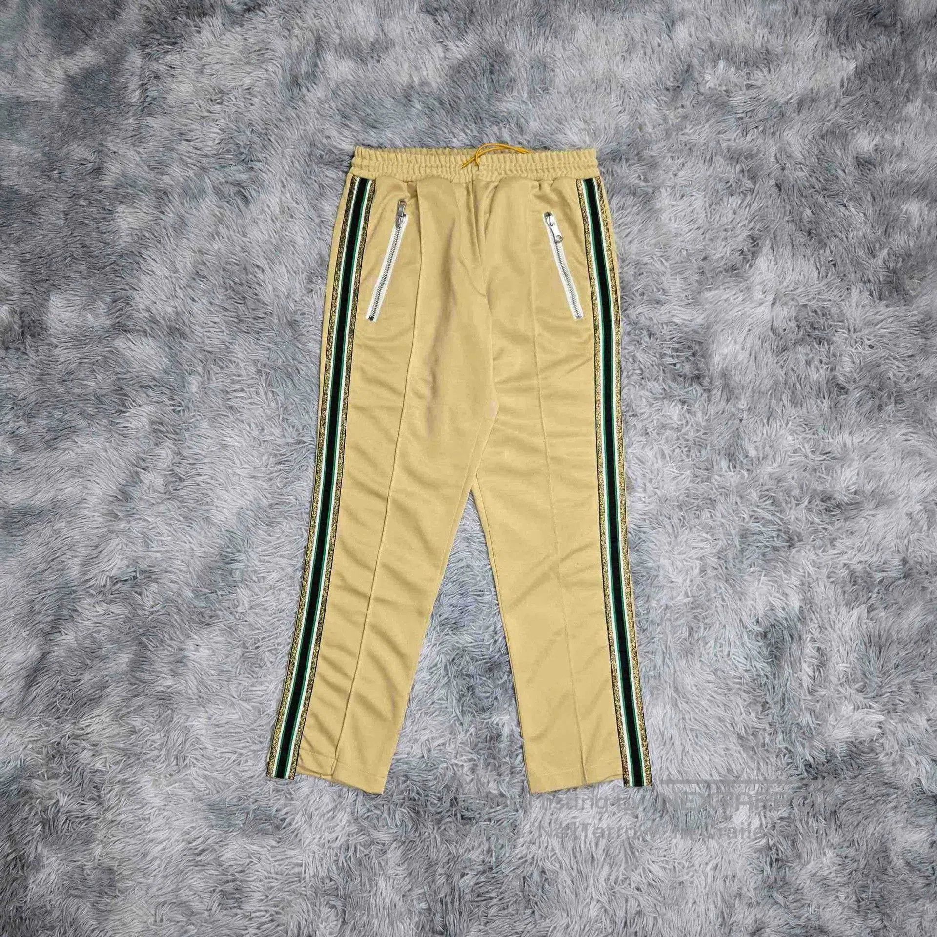 rhude green striped pants with gold details.