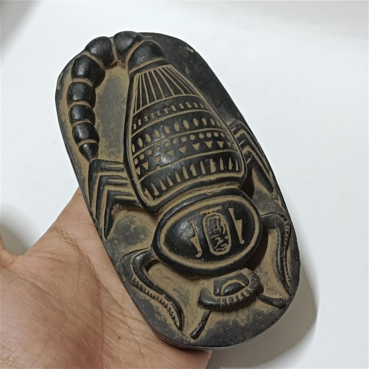Ancient Egyptian scarab stone carving with hieroglyphs