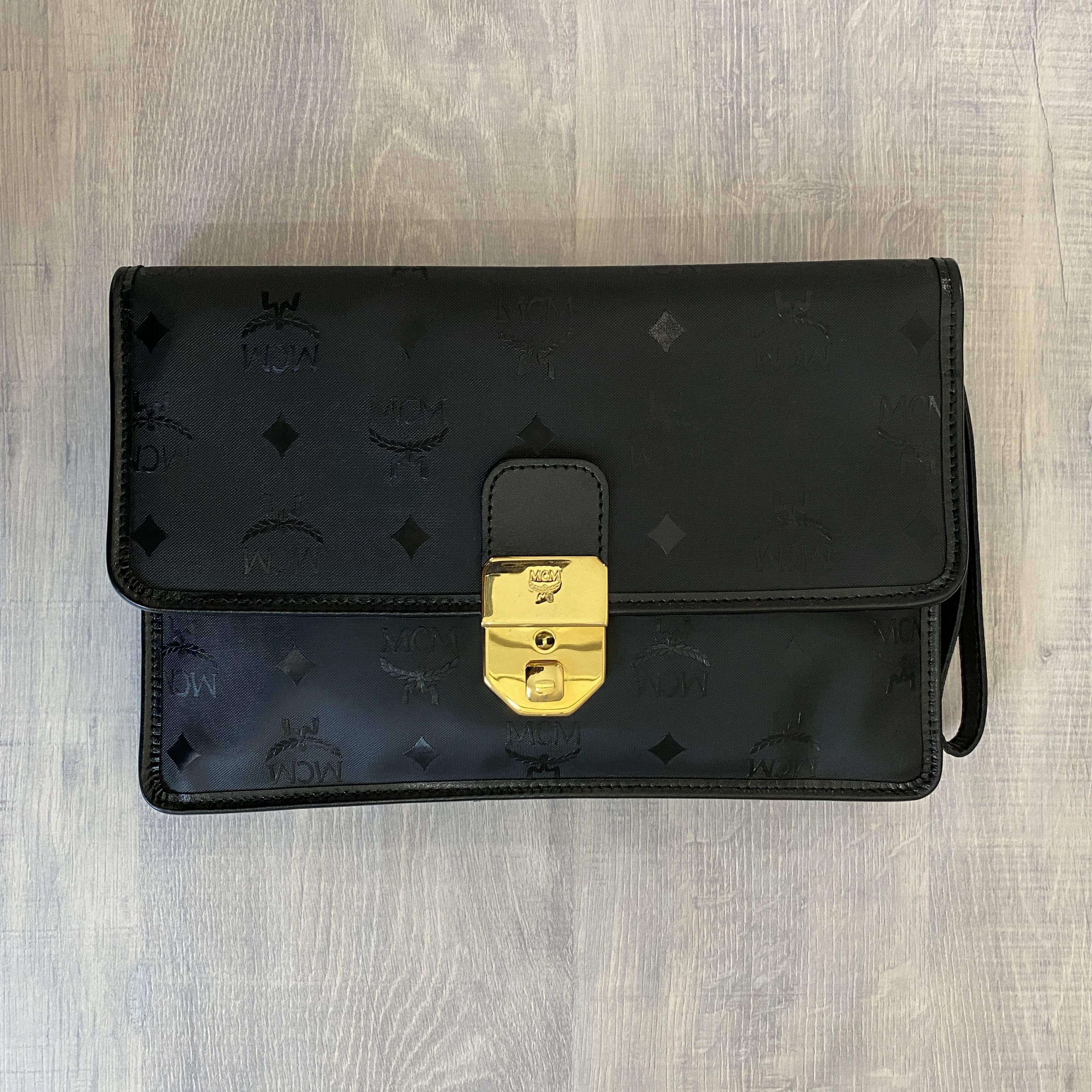 image of MCM All-Over Pattern Clutch Bag Black Gold in Black/Gold, Men's
