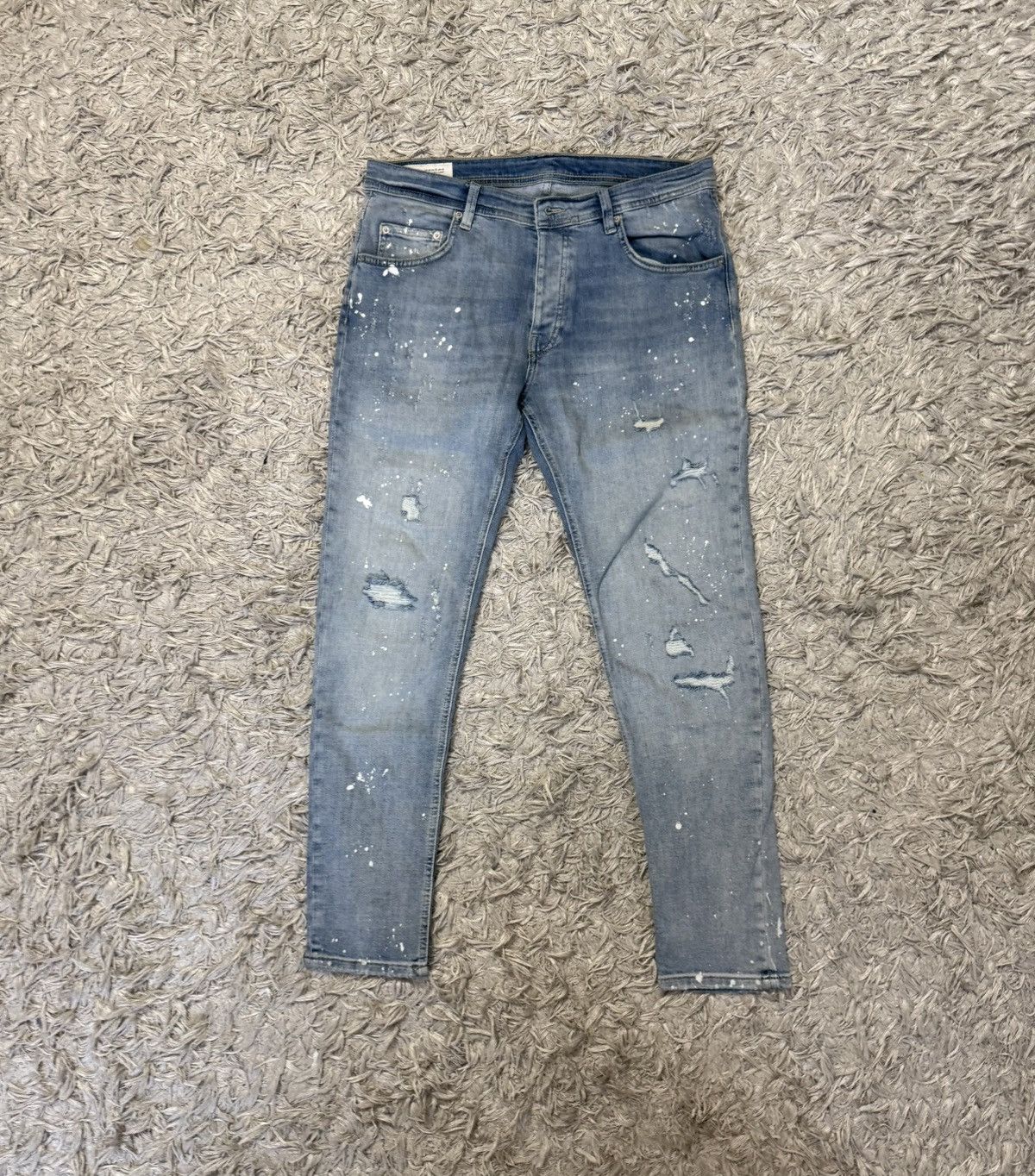 blue ripped jeans with paint splatter