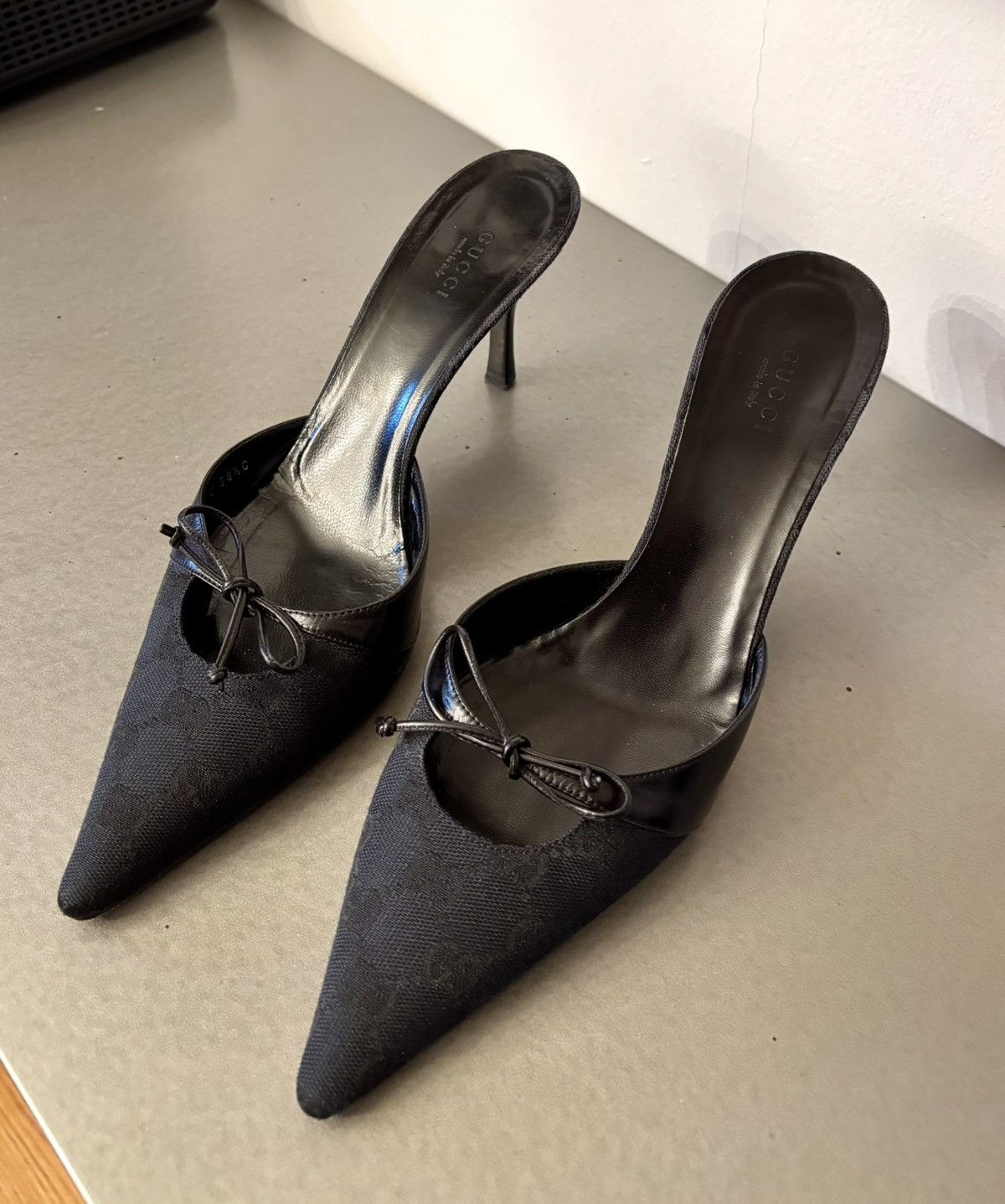 Black monogram mules grommet accents decorative leather bow