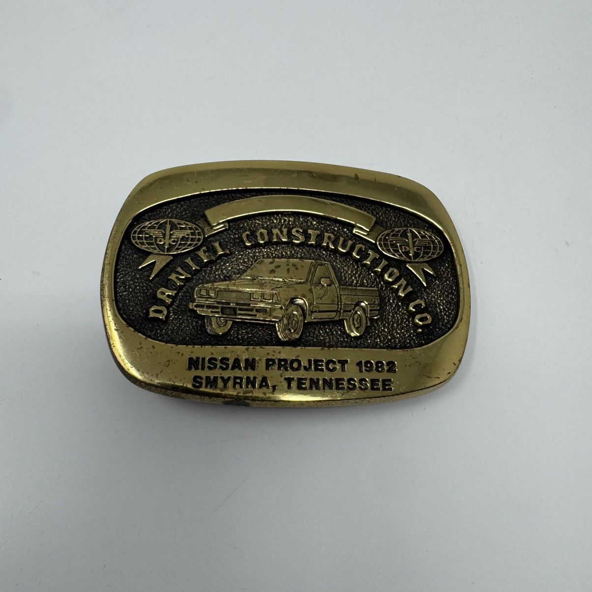 Vintage 1982 Daniel Construction Co Nissan Project Belt Buckle Size ONE SIZE - 1 Thumbnail