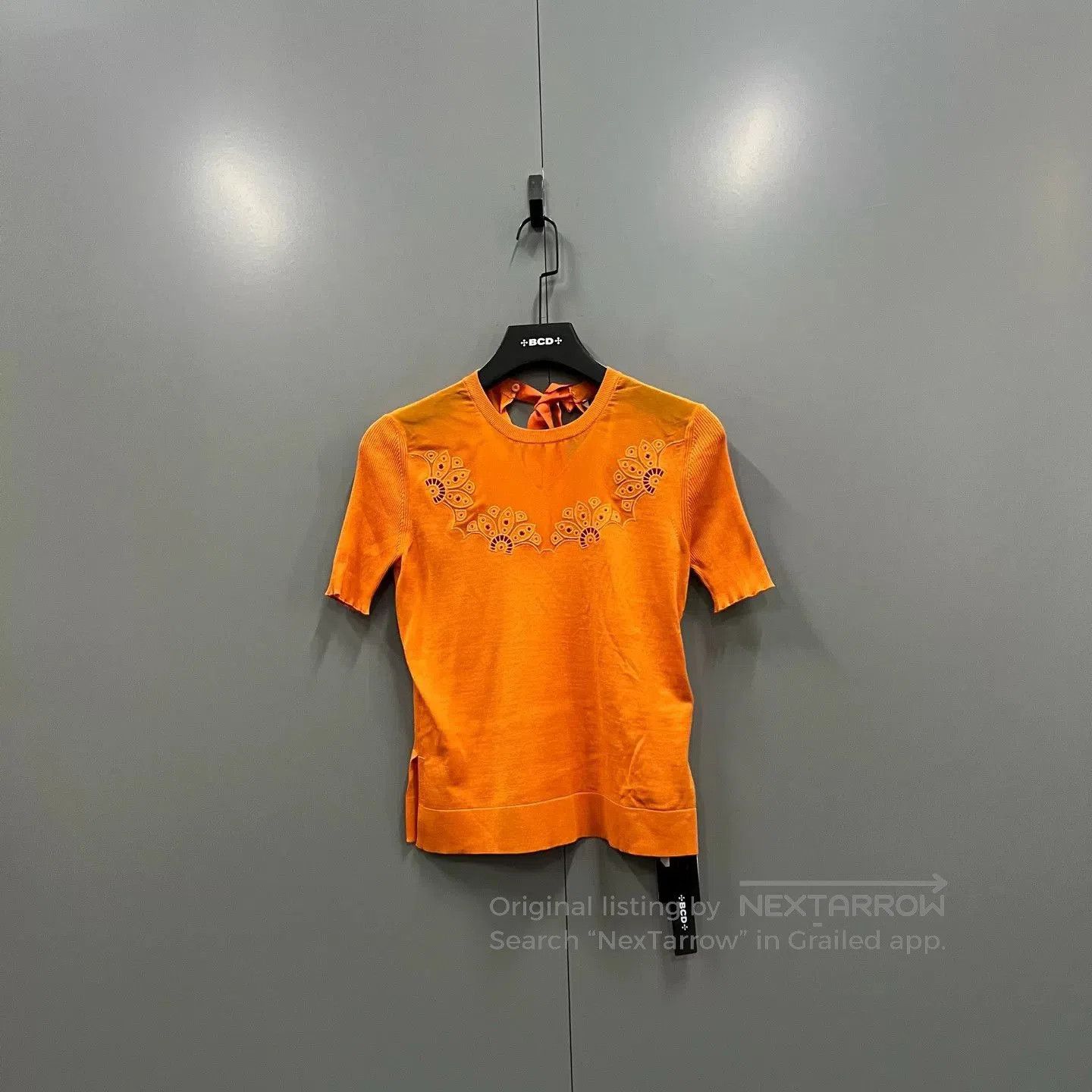 orange embroidered short sleeve sweater.