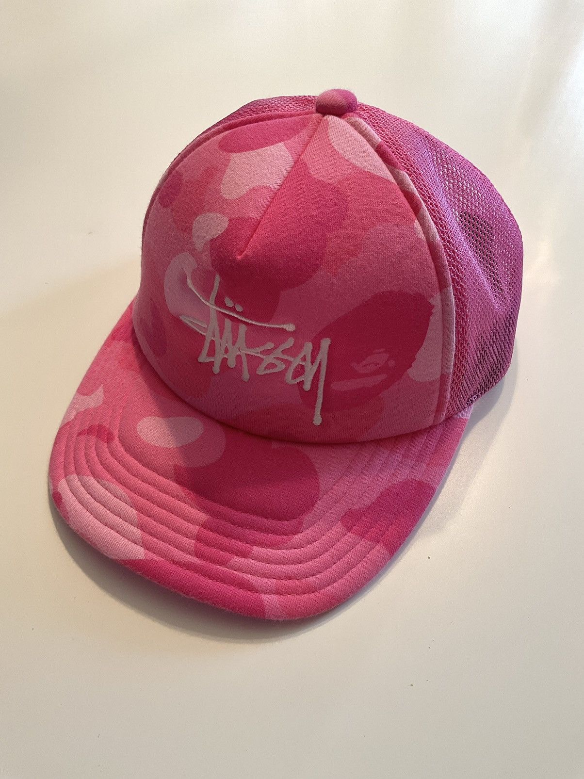image of Bape x Stussy Trucker Hat in Pink, Men's