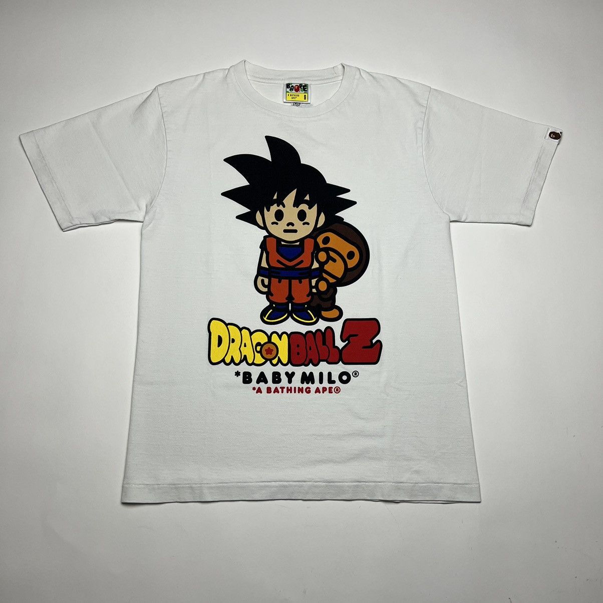 Image of Bape X Dragon Ball Goku Base Baby Milo Tshirt in White, Men's (Size Small)