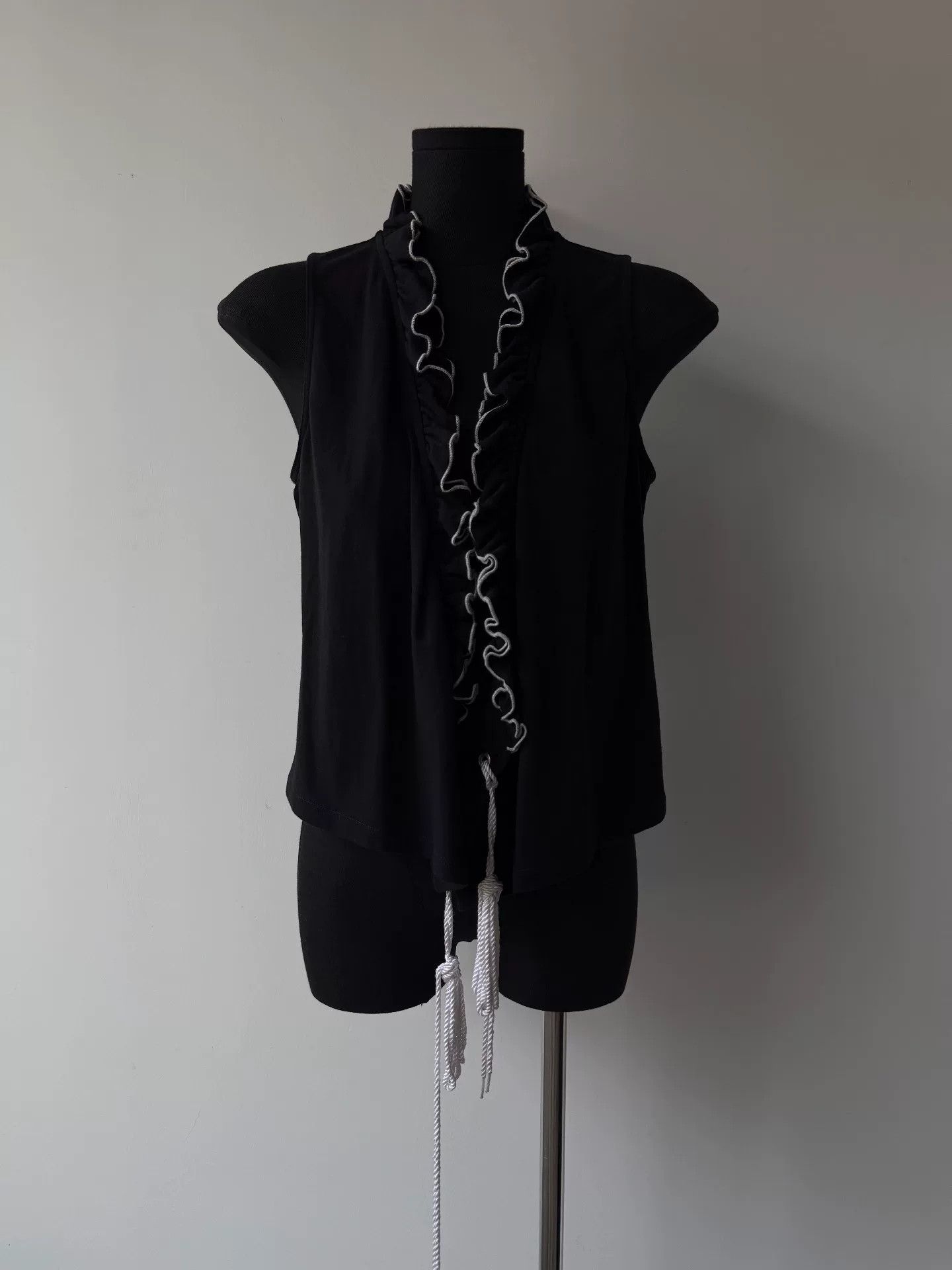 black sleeveless top with ruffles and ties