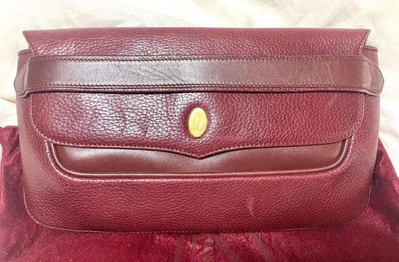 image of Vintage Cartier Wine Leather Clutch Bag With Gold Tone Logo Motif. Classic Purse From Must De Carti