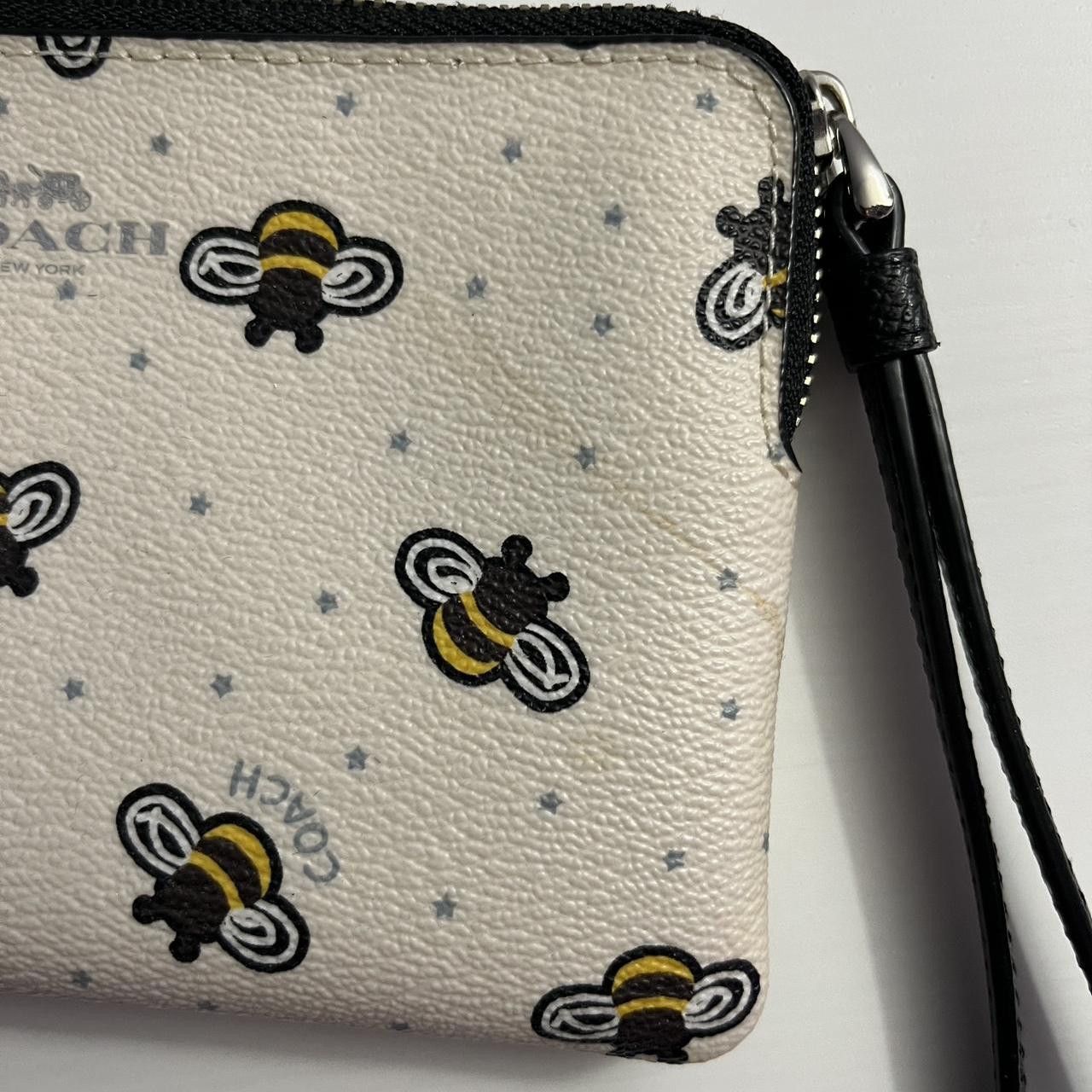 white COACH bumblebee wristlet