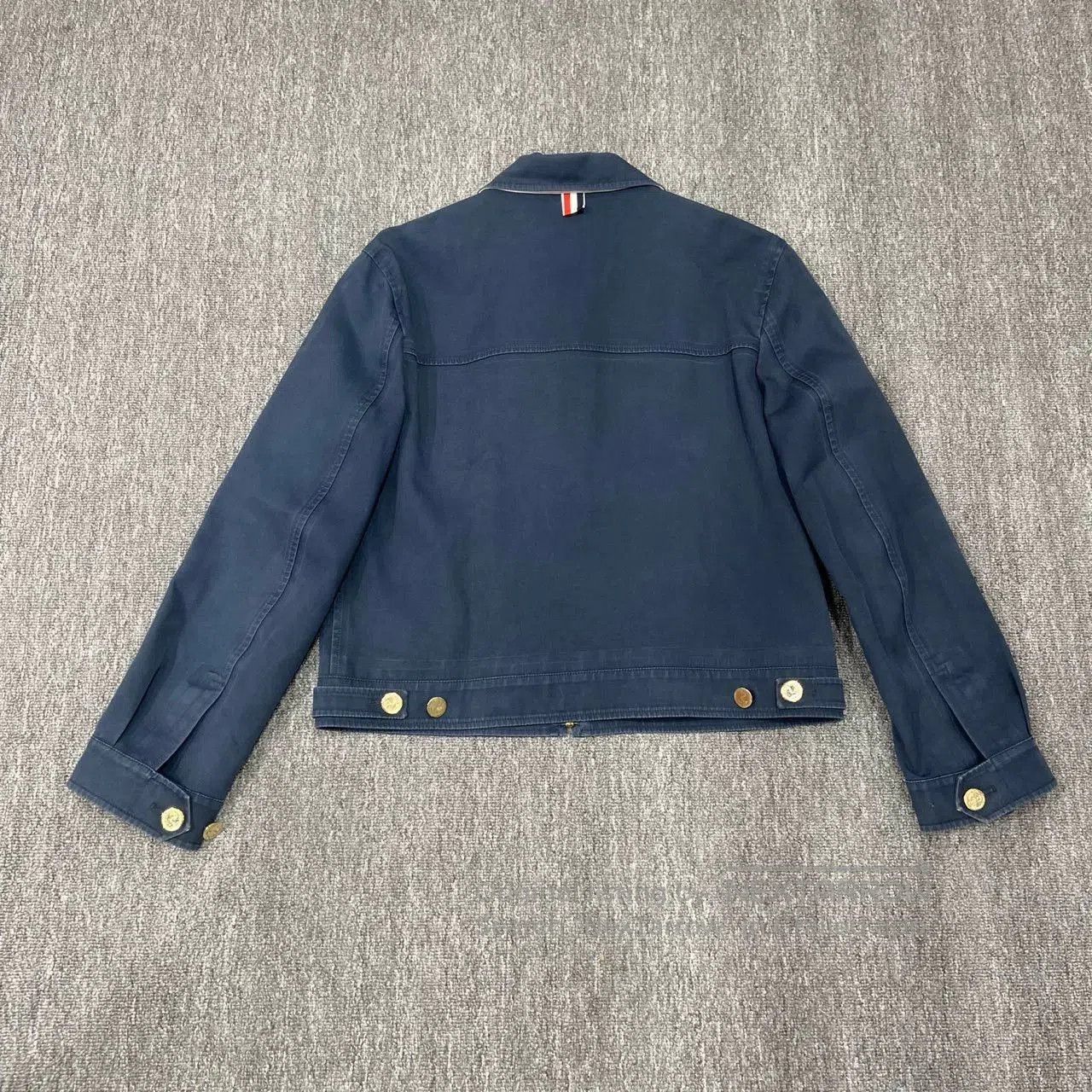 thom browne navy blue jacket with wear marks.
