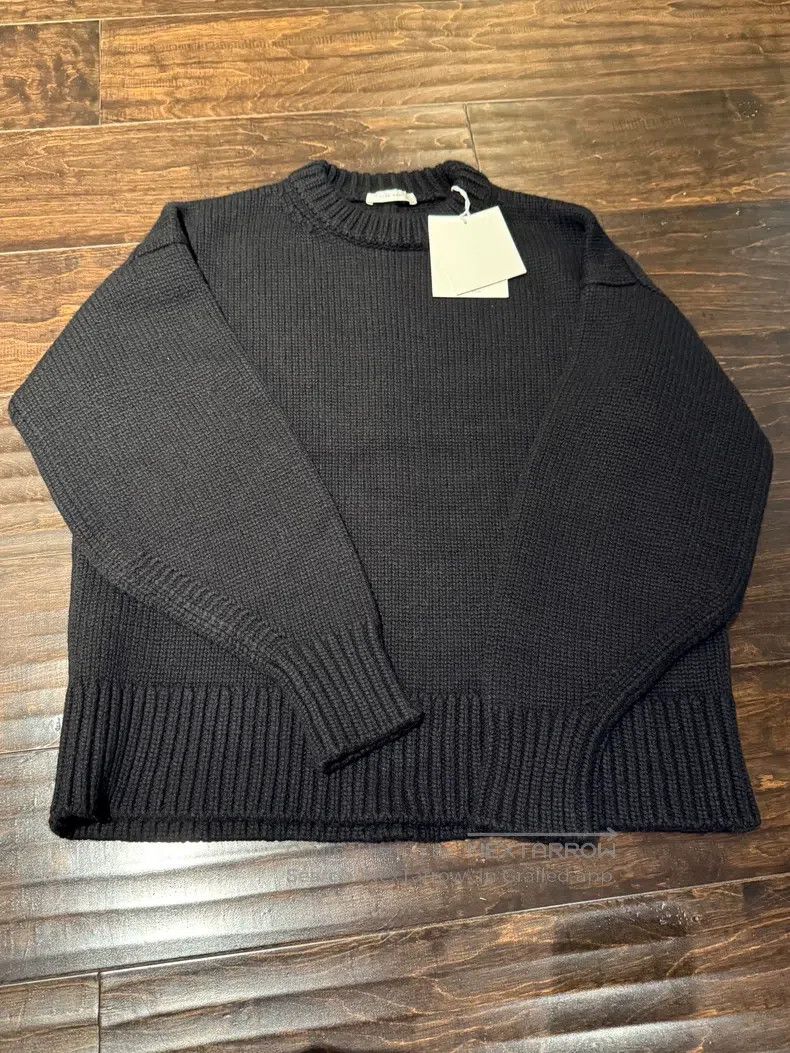 The row Black cashmere knit with long sleeves.