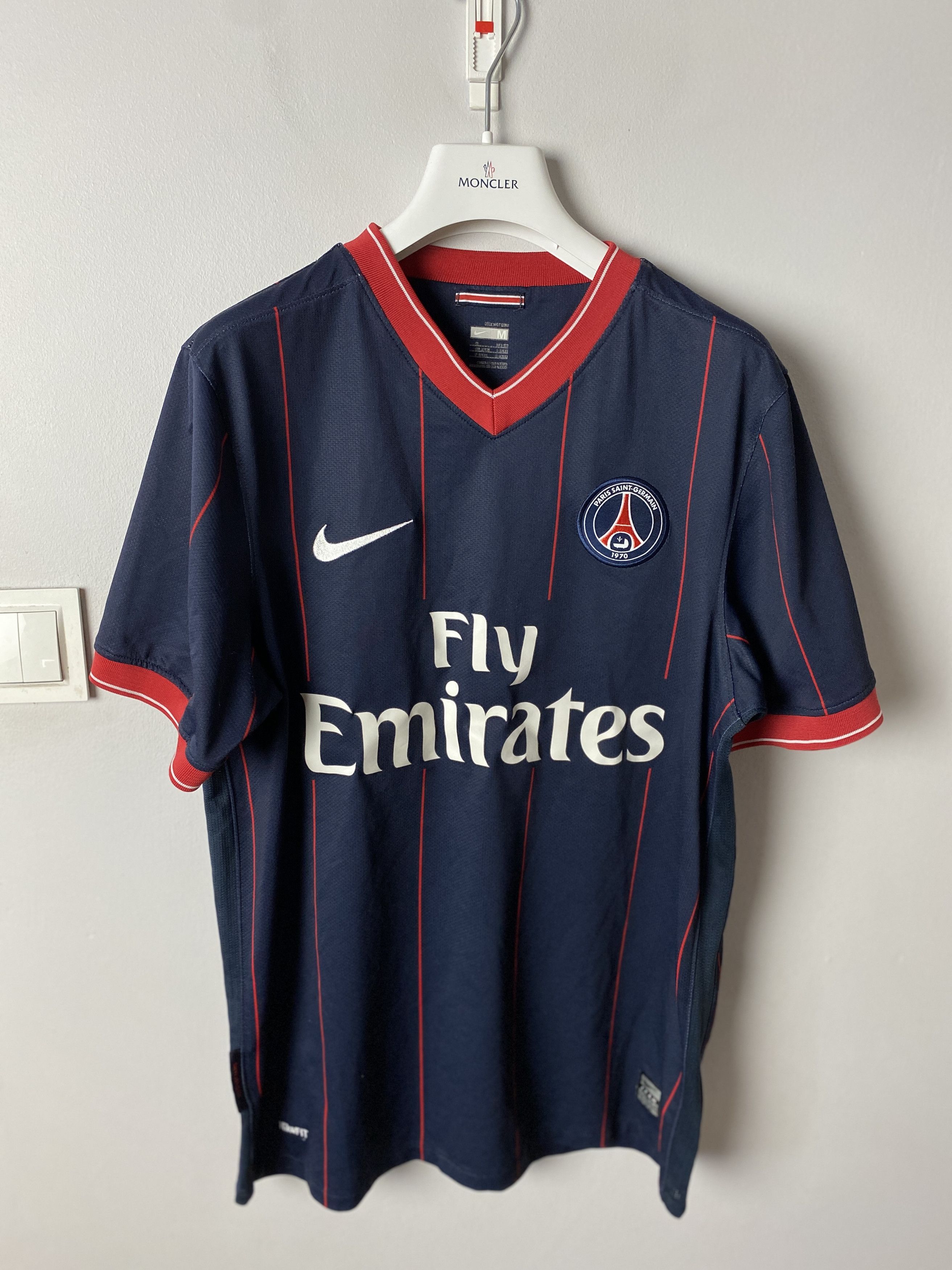 Lucas Beraldo pose avec un maillot vintage du PSG