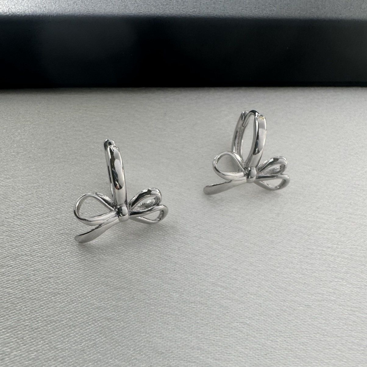 Designer Huggie Bow Silver Hoop Earrings for Women Size ONE SIZE - 1 Thumbnail