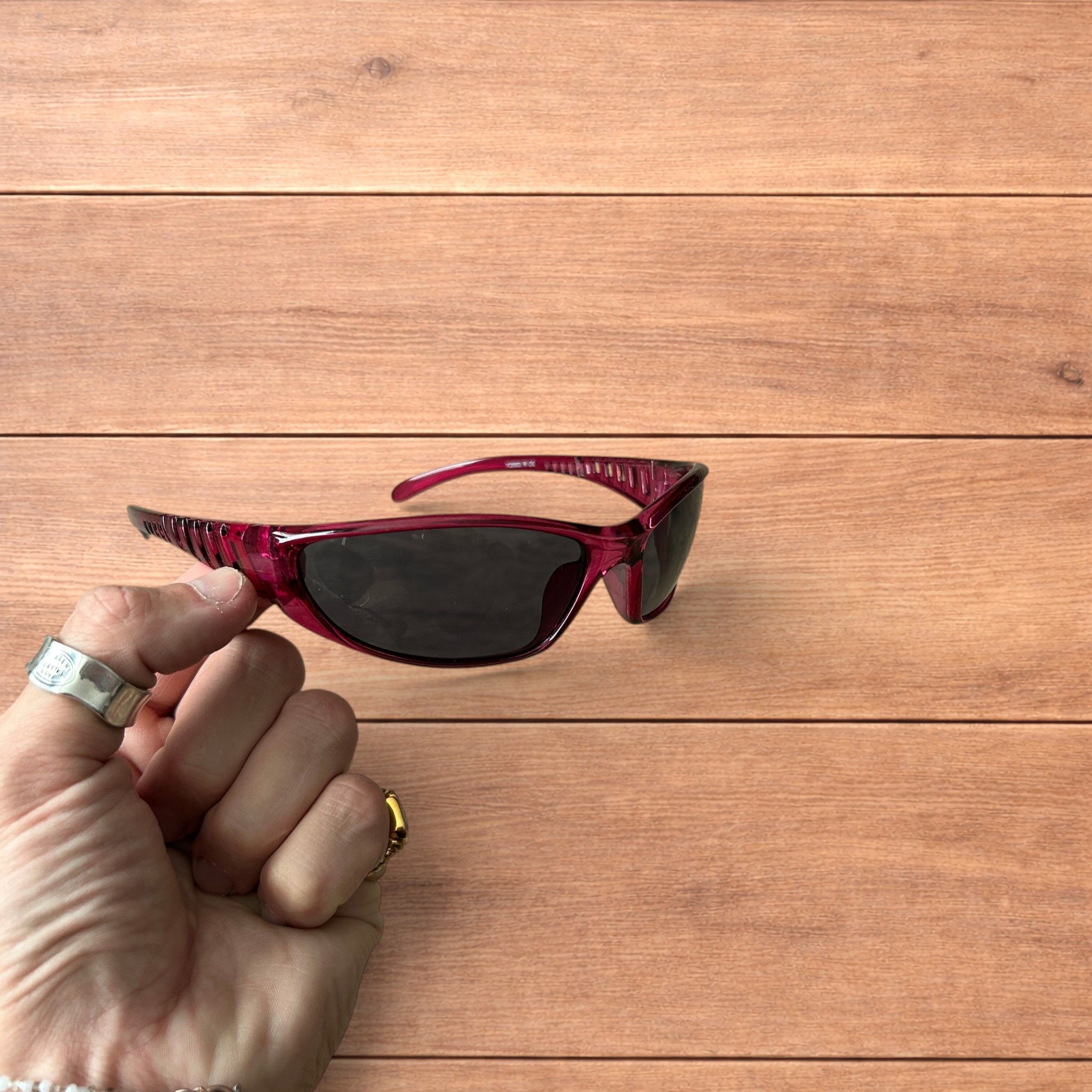 Wrap around sunglasses in pink/purple frame w. black lense.