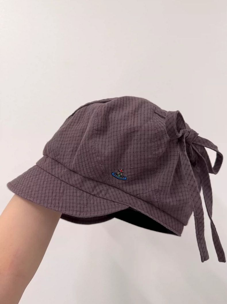 Vivienne Westwood Pulling a newsboy's hat with a duck tong