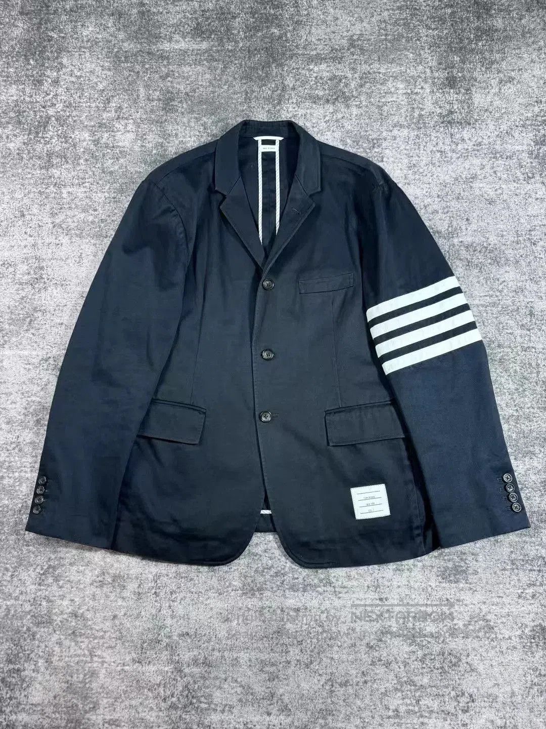 thom browne navy suit with sleeve tag.