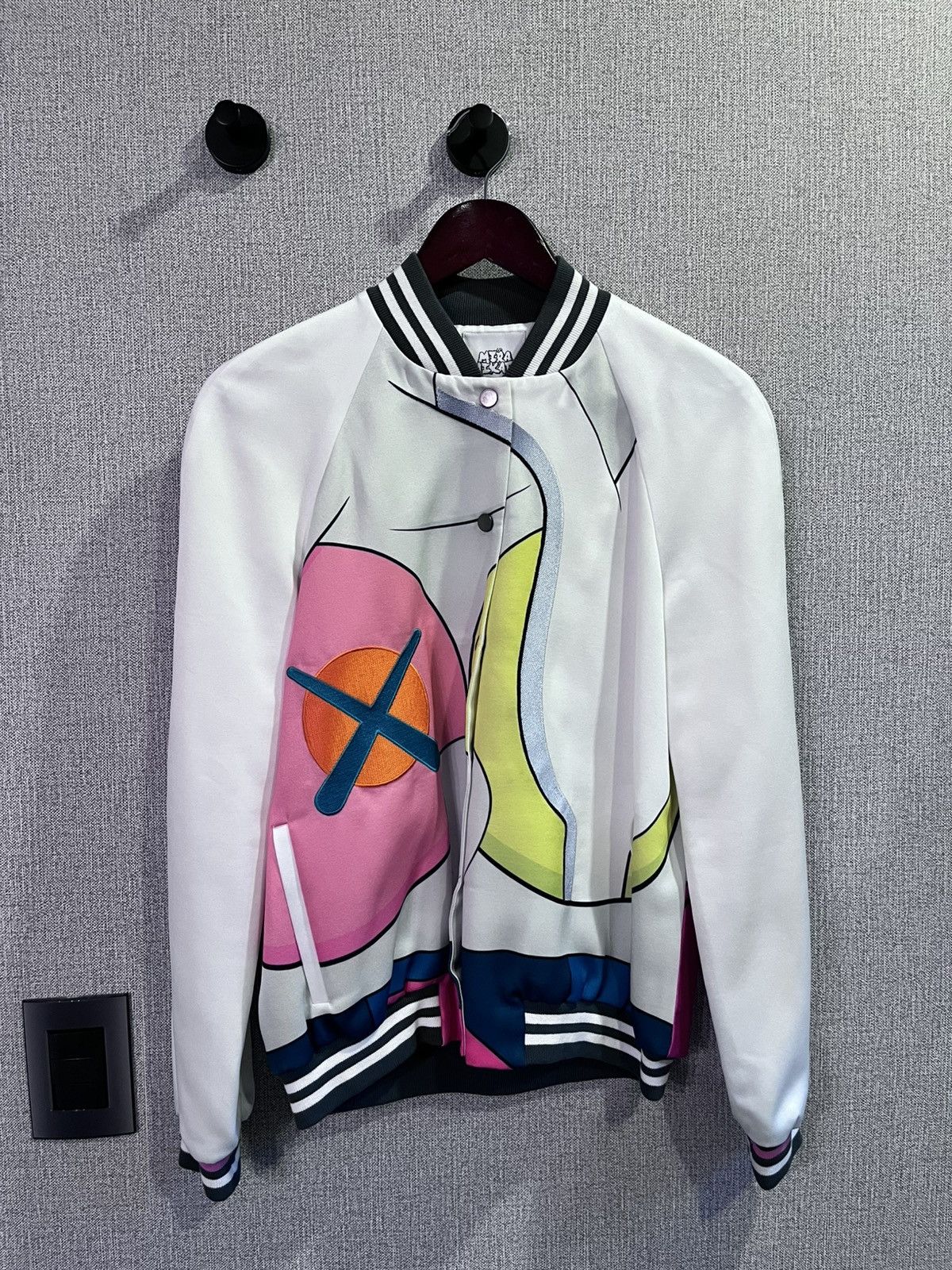 Mira Mikati x KAWS white silk varsity jacket