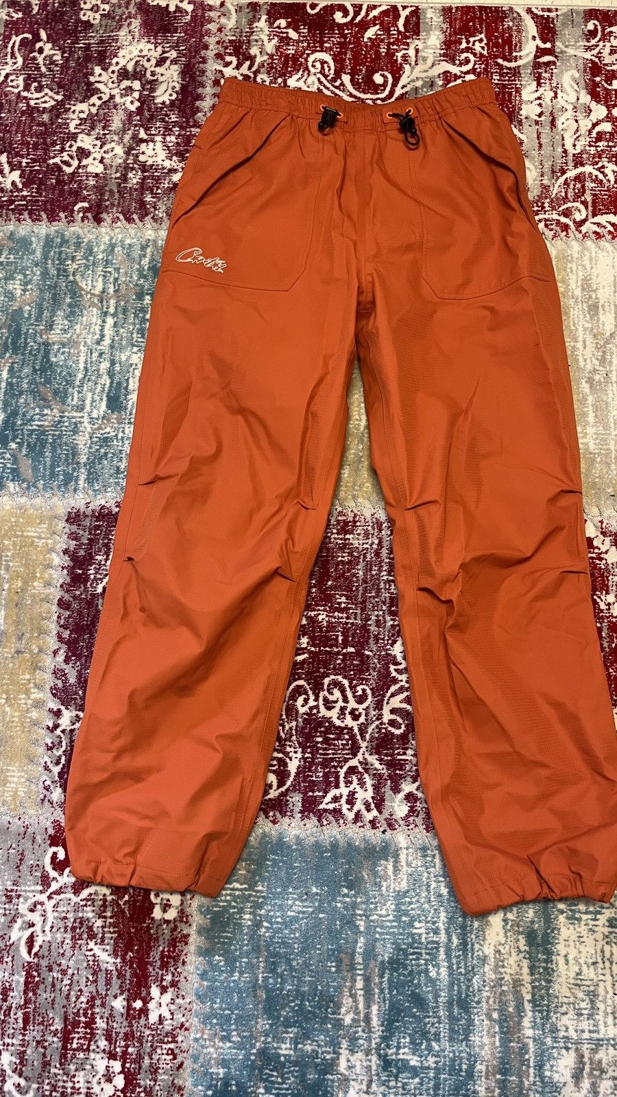 Corteiz GUTTA WATERPROOF BOTTOMS [BURNT ORANGE] | Grailed