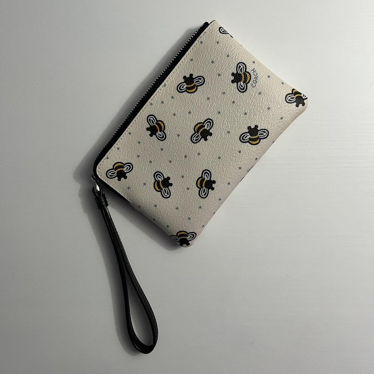 white COACH bumblebee wristlet