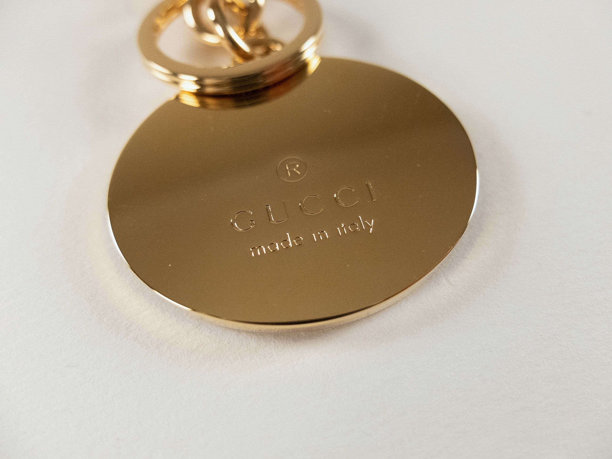 GUCCI gold tone enameled interlocking G logo metal keyring
