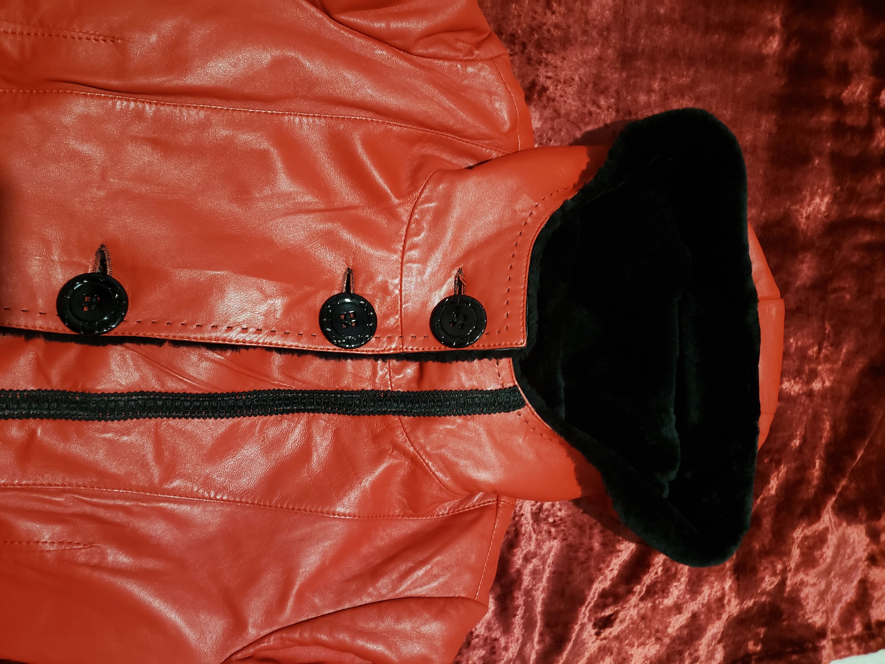 Stylish women's red sheepskin coat with a hood. Fur Faux Fur