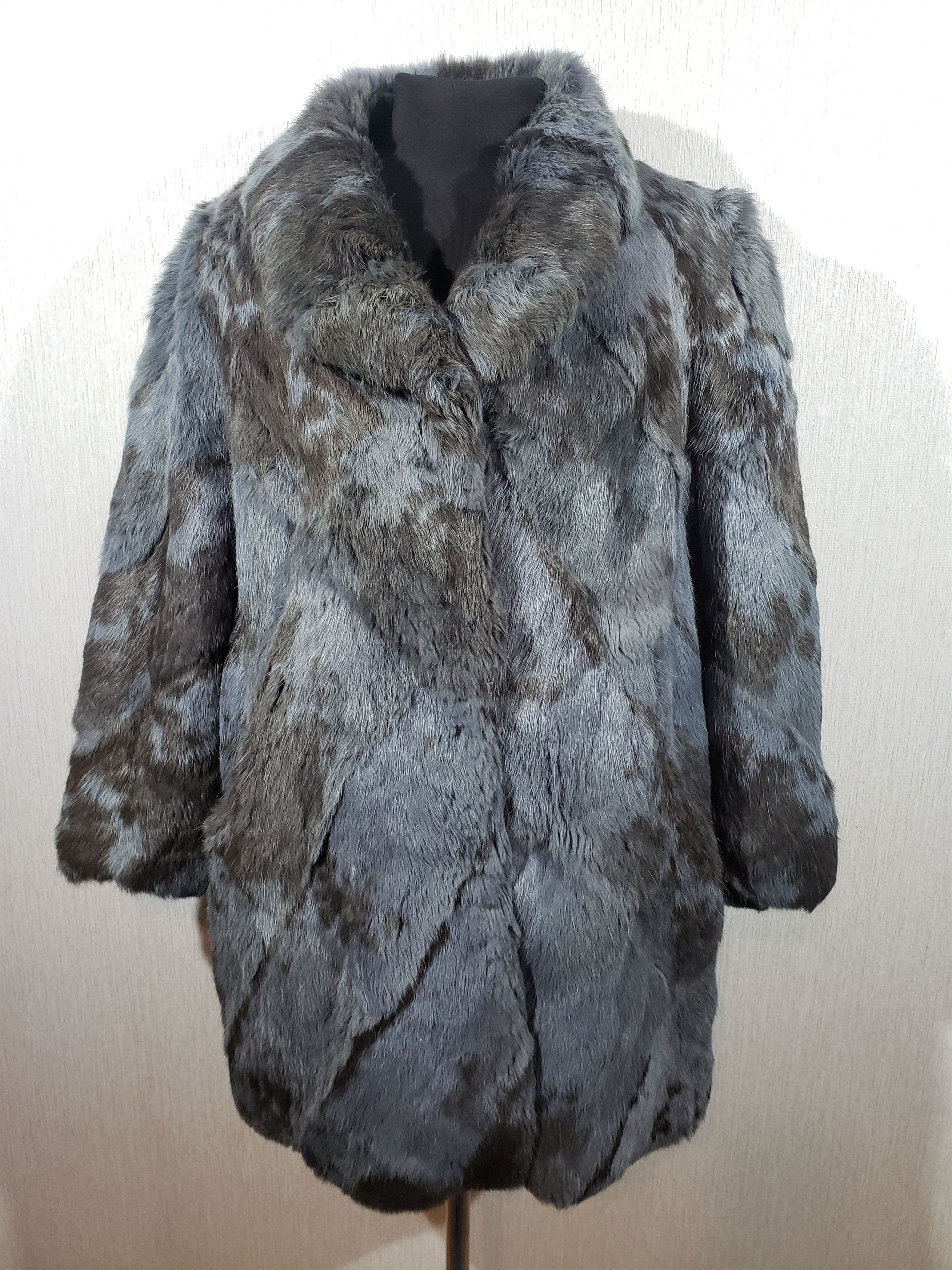 Women's fur coat of warm blue color with genuine fur.