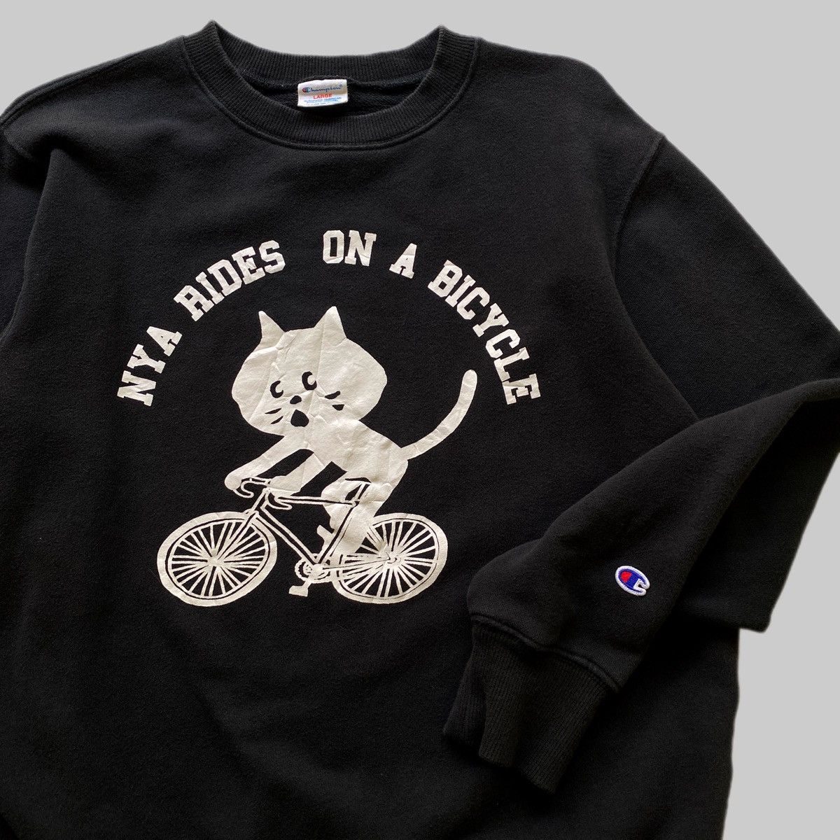Champion × Ne-Net VTG Ne-Net x Champion “Nya Rides on a Bicycle” Size US L / EU 52-54 / 3 - 4 Thumbnail